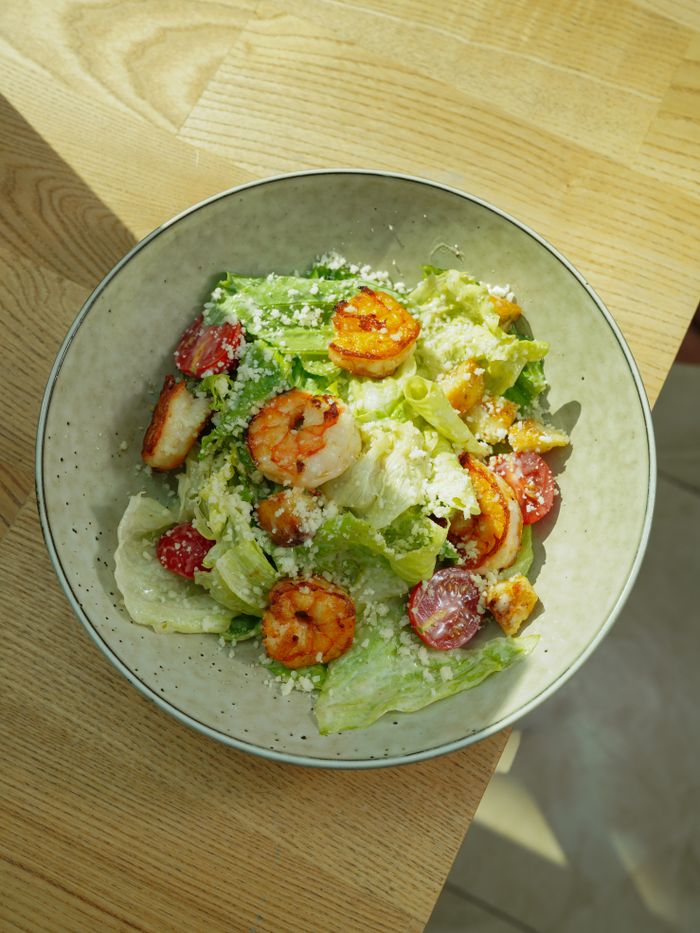 A delicious shrimp salad with lettuce and tomatoes, perfect for a healthy lunch.